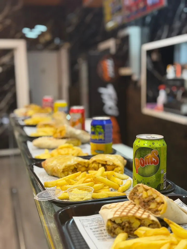 Bandejas con tacos franceses, papas y refrescos en la barra.